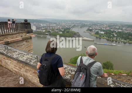 Koblenz, Deutschland. Juni 2021. Touristen stehen auf der Festung Ehrenbreitstein und blicken über die Deutsche Ecke am Zusammenfluss von Rhein und Mosel. Das Urlaubsverhalten der Menschen ändert sich aufgrund der Pandemie - Rheinland-Pfalz könnte davon profitieren. (To dpa: Renaissance des Urlaubs in der Heimat). Quelle: Thomas Frey/dpa/Alamy Live News Stockfoto
