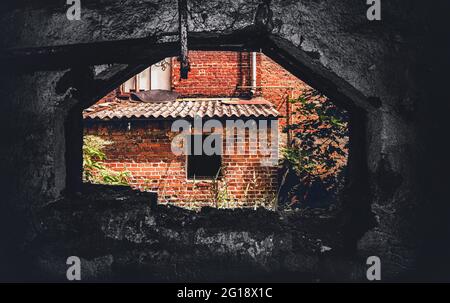 Glänzendes Grauen in einem verlassenen Spukhaus im Wald Blair Witch Project mit einsamen Clowns im Horrorhaus. Fluchtpunkt-Perspektive. Stockfoto