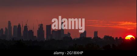 Wimbledon, London, Großbritannien. 6. Juni 2021. Wolkenkratzer im Zentrum von London wurden in diesem aus drei Rahmen zusammengesetzten Panorama vor einem orangefarbenen Sonnenaufgang geschildet. Quelle: Malcolm Park/Alamy Live News Stockfoto