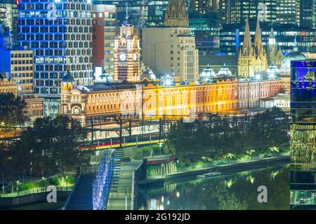 Flinders Street Station in Melbourne, Australien, bei Nacht gesehen, mit Blick auf die Sandridge Bridge, die den Yarra River überquert. Stockfoto