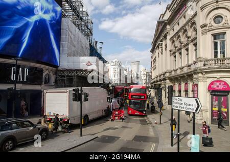 London, Großbritannien - 16. April 2021: Leicht erhöhte Sicht auf die Menschenmassen und den Verkehr am unteren Rand der Shaftesbury Avenue an einem sonnigen Nachmittag in London. Stockfoto