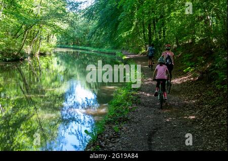 Fahrradtour mit der Familie durch die englische Landschaft entlang des Kanals bei strahlendem Sonnenschein an einem Sommertag. Vergeht Zeit im glorreichen Juni. Stockfoto