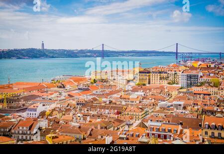 Panorama-Luftaufnahme der alten traditionellen Stadt Lissabon mit orangefarbenen Dächern und der Brücke vom 25. April vom Castelo de Sao Jorge, Portugal. Stockfoto