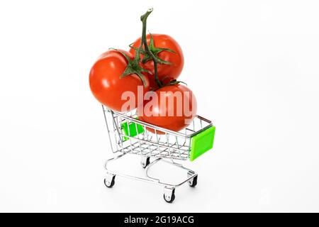 Drei reife Tomaten in einem Lebensmittelkarren. Herbsternte von Gemüse. Stockfoto