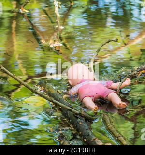 Puppe schwimmt verdeckt im Kanal - Horror Stockfoto