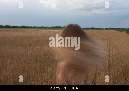 Eine Person, die auf einem mit Gras bedeckten Feld steht Stockfoto