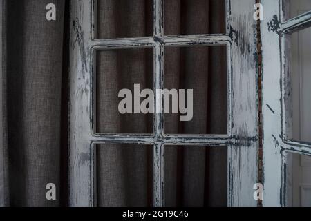 Vintage Holzfenster mit verblassenden weißen Farben auf dunklem Hintergrund. Stockfoto