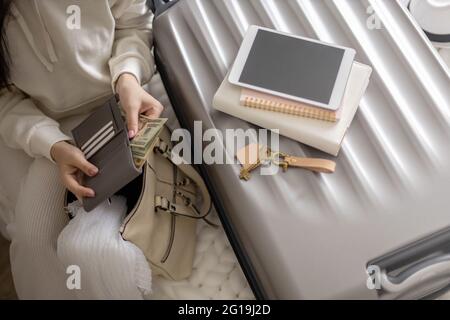 Weibliche Hände halten Bargeld Geld Dollar in der Brieftasche mit Karten bereit Reise Urlaub oder Geschäftsreise Stockfoto