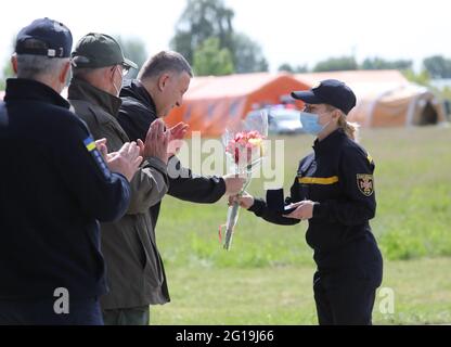 Non Exclusive: HAI, UKRAINE - 4. JUNI 2021 - der ukrainische Innenminister Arsen Avakov überreicht eine Auszeichnung und einen Blumenstrauß an eine Resc Stockfoto