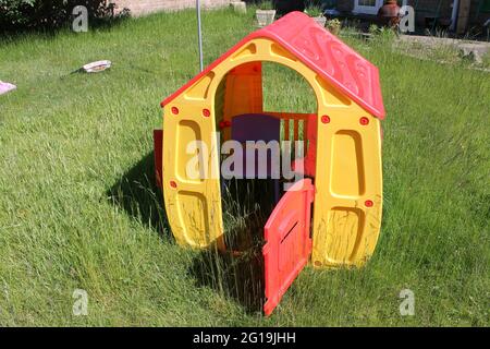 Kinderspielhaus in einem langen, mit Gras bewachsenen Garten Stockfoto