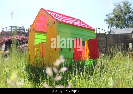 Kinderspielhaus in einem langen, mit Gras bewachsenen Garten Stockfoto