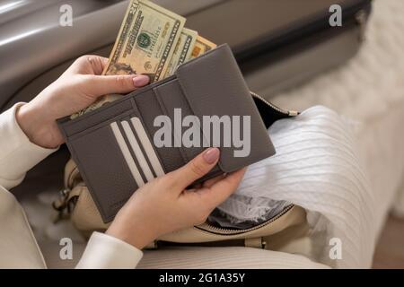 Weibliche Hände halten Bargeld Geld Dollar in der Brieftasche mit Karten bereit Reise Urlaub oder Geschäftsreise Stockfoto