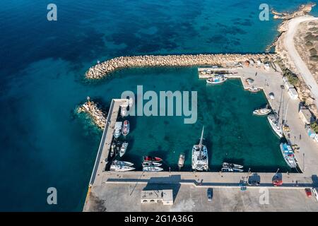 Griechenland, Insel Koufonisi, kleine Kykladen. Blick auf die Luftdrohne von Marina. Fischerboote und Segelboote ankerten im Hafen. Ruhige smaragdgrüne Farbe Meerwasser BA Stockfoto