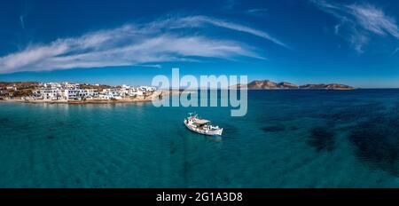 Griechenland, Koufonisi Island Luftdrohne Panoramablick. Traditionelles Fischerboot aus Holz vor Anker, ruhiges smaragdgrünes Meerwasser und blauer Himmel im Hintergrund. Sommer h Stockfoto