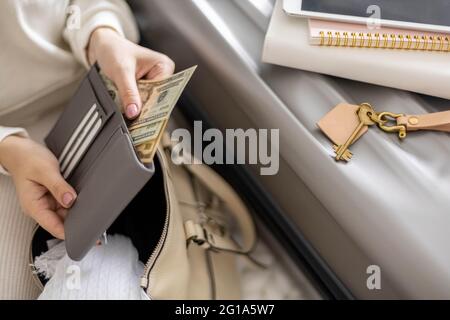 Weibliche Hände halten Bargeld Geld Dollar in der Brieftasche mit Karten bereit Reise Urlaub oder Geschäftsreise Stockfoto