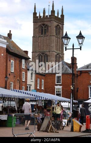 Ludlow in Shropshire am Markttag.lebendige Straßenszene mit dem Glockenturm der St. Laurence's Church aus dem 11. Jahrhundert, der "Kathedrale der Marken". Stockfoto