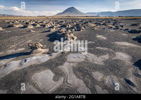 Wattflächen in der Nähe des Natron-Sees mit dem Vulkan Ol Doinyo Lengai im Hintergrund; Tansania Stockfoto