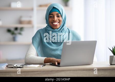 Freiberuflich. Afrikanische Muslimische Frau In Hijab Arbeitet Mit Laptop Im Home Office Stockfoto