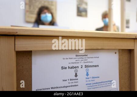 Treseburg, Deutschland. Juni 2021. Bei den Landtagswahlen in Sachsen-Anhalt sitzen Wahlhelfer vor einer Wahlurne in einem Wahllokal. In der kleinen Gemeinde gibt es 66 Wahlberechtigte. Quelle: Matthias Bein/dpa-Zentralbild/dpa - ACHTUNG: Nur im Vollformat verwenden/dpa/Alamy Live News Stockfoto