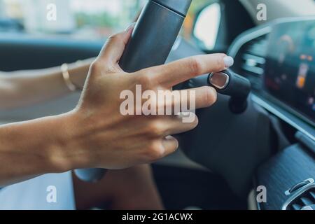 Die Frauenhand schaltet die Noppen des Wählhebels am Lenkrad. Die Hand schaltet den Autoschalthebel, Nahaufnahme eines manuellen Gangwechsels Stockfoto