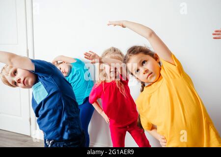 Kinder machen Stretching-Übungen vor dem Gymnastik-Training Stockfoto