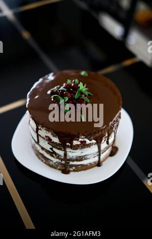 Brownie-Schokoladenkuchen mit Kirschen und Frischkäse auf einem Tisch. Draufsicht Stockfoto