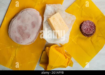 Käse-, Salami- und Schinkenscheiben in Bienenwachspapier verpackt Stockfoto