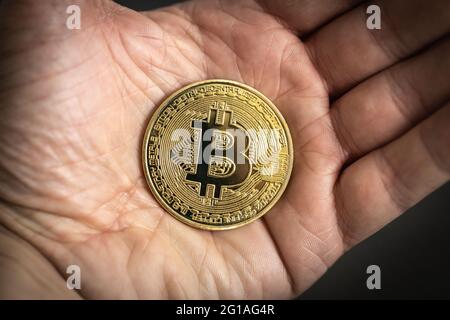 Bitcoin physische Münze in der Hand gehalten. Stockfoto