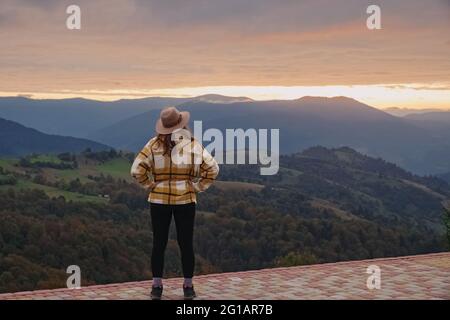 Frauengenießend Sonnenuntergang und schöne Landschaft in den Bergen. Stockfoto
