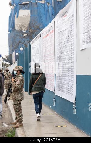 Am 2021. Juni wird über den neuen Präsidenten Perus abgestimmt. Peruanische Menschen sind an der Wahlstelle, während Polizei und Streitkräfte vor der Tür stehen Stockfoto