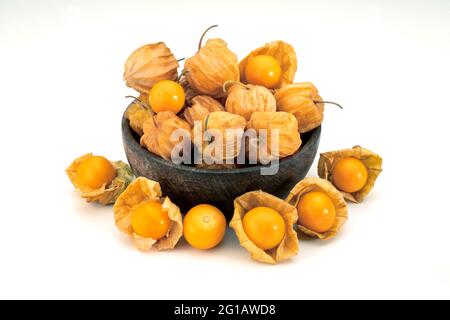 Nahaufnahme von oben Ansicht von reifen goldenen Cape Gooseberry, Rasbhari, Physalis peruviana Beeren in Holzschale vor weißem Hintergrund. Stockfoto