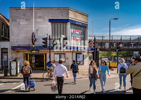 Menschen, die die Straße vor der U-Bahn-Station Balham im Süden Londons überqueren, die Haltestelle Balham liegt an der Northern Line und auch an der Southern National Rail Stockfoto