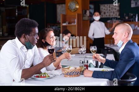 Positive Gäste, die während der Quarantäne im Café essen und trinken Stockfoto