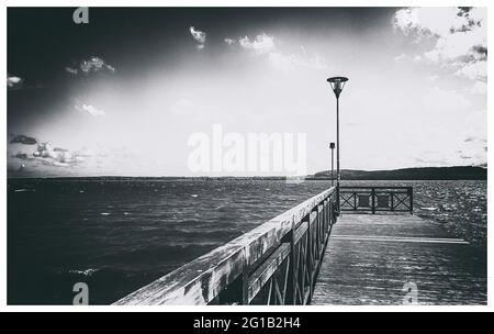 Promenade und Anlegestelle am Strand des Sees Tsarnowice in Polen an einem warmen Sommertag. Am Ufer einer wunderschönen Bucht und einem Angelplatz. Stockfoto