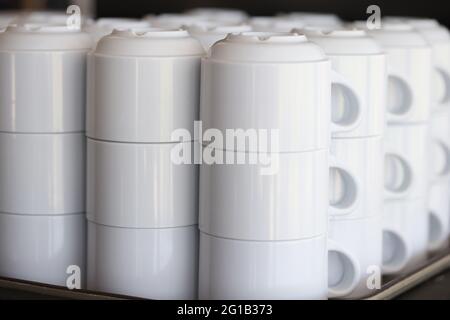 Viele Reihen reinweißer Kaffeetassen auf dem Tablett Stockfoto