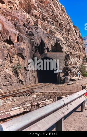 Schöne Aufnahme von Eisenbahnschienen, umgeben von Natur, die zum dunklen Tunnel führt Link × Titel: Schöne Aufnahme von Eisenbahnschienen, umgeben von Natur, die führt Stockfoto