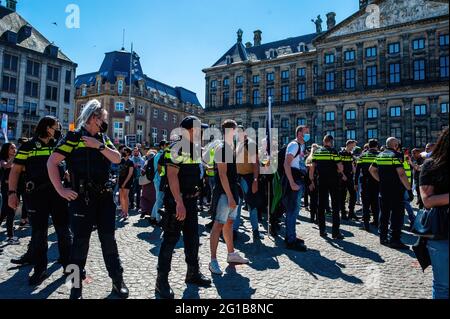 Polizeibeamte umgeben palästinensische Demonstranten während einer pro-palästinensischen Demonstration auf dem Dam-Platz in Amsterdam. Während einer pro-palästinensischen Demonstration, die von der palästinensischen Gemeinde in den Niederlanden auf dem Dam-Platz in Amsterdam organisiert wurde, Es kam zu Konflikten zwischen Palästinensern und einigen Israelis, die zur gleichen Zeit und am gleichen Ort demonstrierten. Einige von ihnen wurden während der Kämpfe verletzt und von der niederländischen Polizei festgenommen. Danach ging die Pro Palestine-Demonstration ohne weiteres Problem voran. Stockfoto