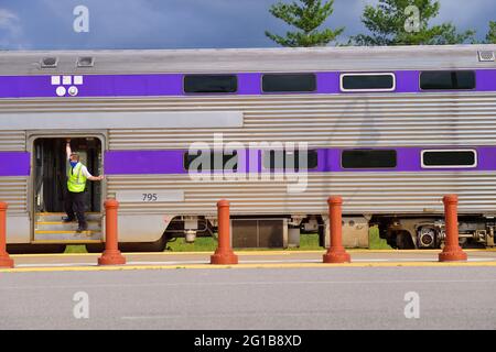 Hermitage, Tennessee, USA. Ein Dirigent signalisiert dem Techniker an Bord eines einkommenden Music City Star-Pendlerzuges, der den Bahnhof abfahren wird. Stockfoto