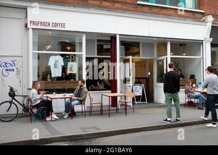 Menschen Kunden soziale Distanzierung außerhalb Prufrock Coffee Shop während Covid 19 Pandemie in Exmouth Market London England Großbritannien KATHY DEWITT Stockfoto