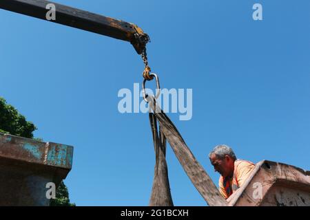 Dnepropetrovsk, Ukraine - 05.28.2021: Müllcontainer mit einem Kran in einen LKW laden. Slinger funktioniert. Stockfoto