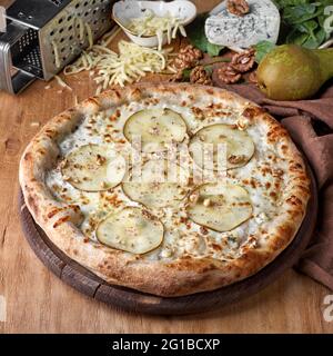 Birne und Blauschimmelkäse Pizza garniert mit frischen Rucola auf Pizzabrett, Fast Food Mittagessen für Picknick Gesellschaft, Foto für das Menü Stockfoto