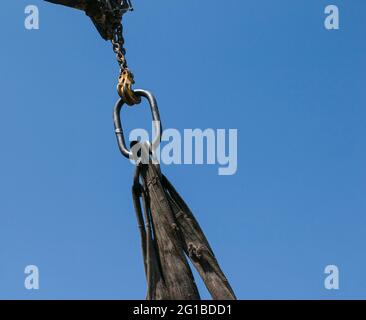 Verladen von Müllcontainern mit einem Kran in einen LKW. Slinger funktioniert. Stockfoto