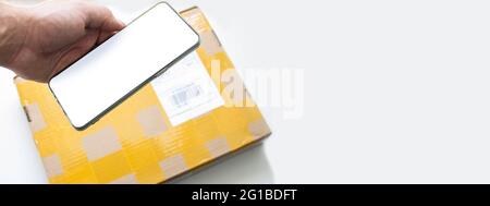 Scannt das Paket mit Ihrem Telefon. Versenden eines Pakets aus China. Empfang der Paketpost. Der Postbote lieferte die Post. Scannen eines Barcodes. Stockfoto