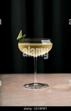Elegantes Glas Champagner-Cocktail aus Glas in Glas mit Limettenscheibe, serviert auf der Marmortheke im Restaurant Stockfoto