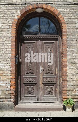 Alte hölzerne geschnitzte Doppeltür, Backsteingebäude Eingang. Bialystok, Polen, Europa. Stockfoto