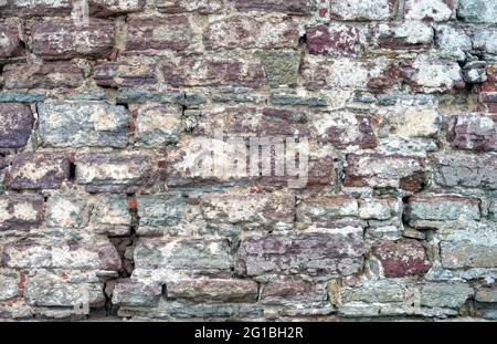 Textur einer alten zerstörten Steinmauer aus dem 17. Jahrhundert. Abstrakter Hintergrund mit Kopierbereich Stockfoto