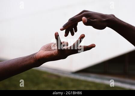 Crop unkenntlich afroamerikanischen Menschen die Hände zu einander für die Einheit Unterstützung und Hilfe zu erreichen Stockfoto