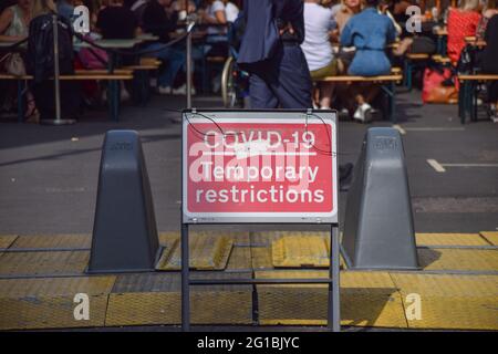 London, Großbritannien. Juni 2021. Ein COVID-19 Temporary Restrictions-Schild, das in der Old Compton Street, Soho, zu sehen ist. Mehrere Straßen im Zentrum Londons wurden zu bestimmten Tageszeiten für den Verkehr gesperrt, um während der Coronavirus-Pandemie Sitzplätze im Freien, in Pubs, Bars und Restaurants zu ermöglichen. Kredit: Vuk Valcic/SOPA Images/ZUMA Wire/Alamy Live Nachrichten Stockfoto