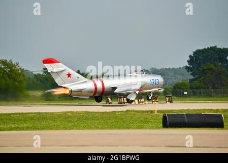 Russische Hochunterschall-Kampfflugzeuge MiG-17, mit Strahltriebwerken, die beim Start auf der Start- und Landebahn des EAA Fly-in (AirVenture), Oshkosh, Wisconsin, aufflammen Stockfoto