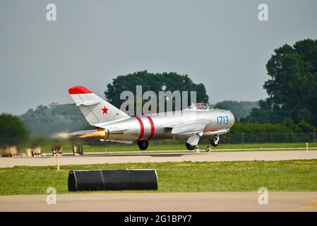 Russische Hochunterschall-Kampfflugzeuge MiG-17, mit Strahltriebwerken, die beim Start auf der Start- und Landebahn des EAA Fly-in (AirVenture), Oshkosh, Wisconsin, aufflammen Stockfoto